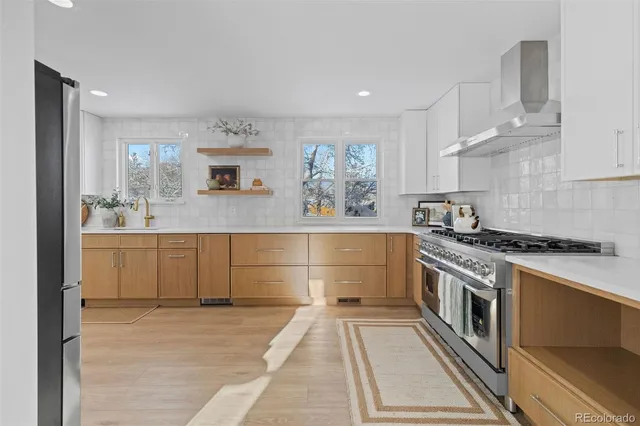 a kitchen with stainless steel appliances granite countertop a stove a sink and a refrigerator