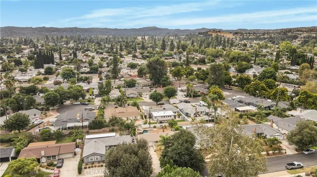 an aerial view of residential houses with outdoor space and trees