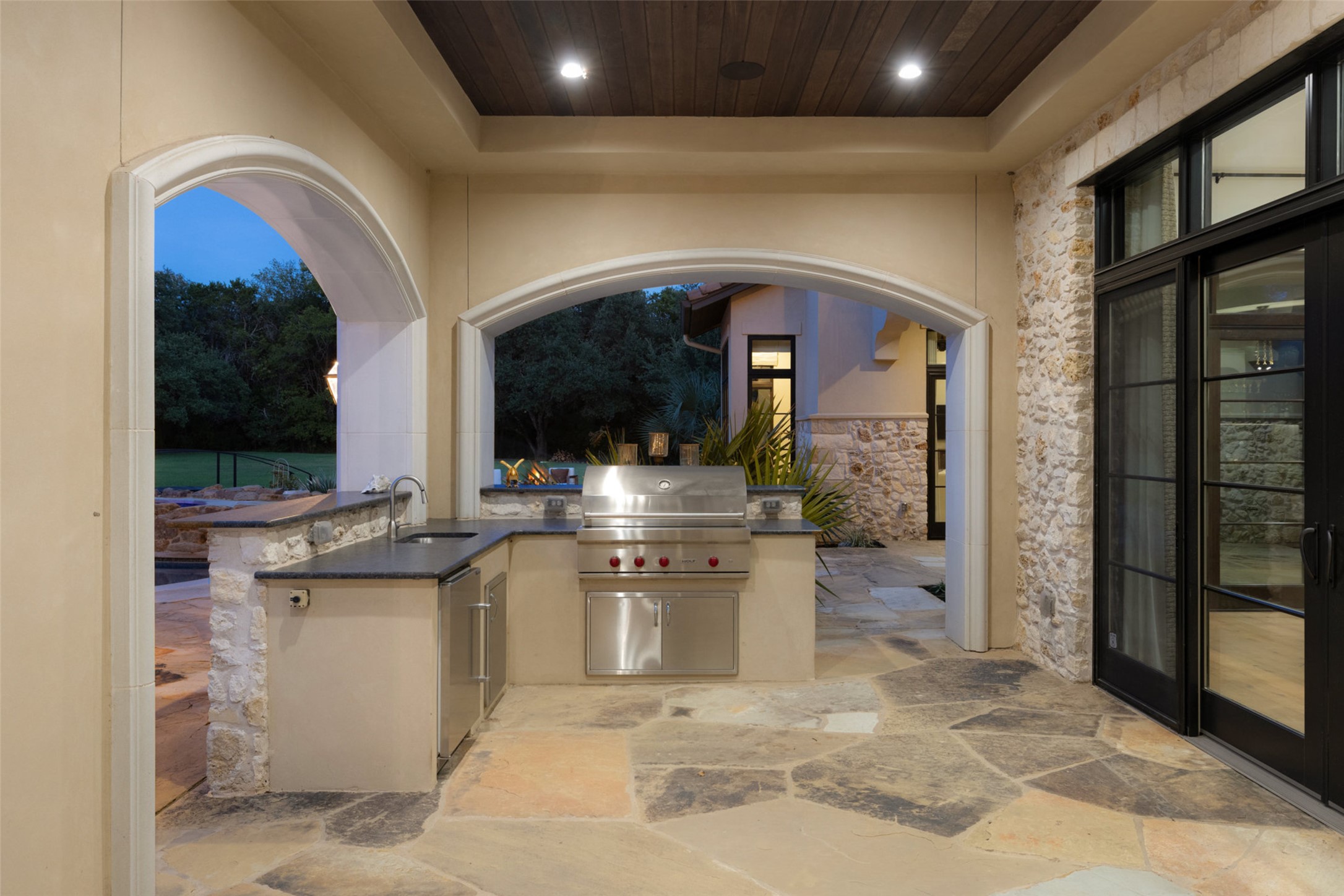 3667 Stoneridge Road Austin, TX 78746 - Photo 38 of 40 The outdoor kitchen is fully equipped with a built-in grill, sink, and mini refrigerator, designed to support effortless outdoor entertaining.