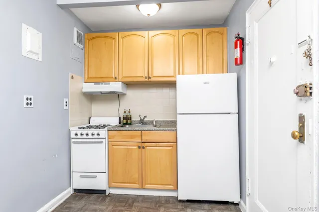 a kitchen with a refrigerator a stove and a window