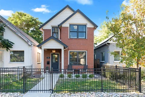 a front view of a house with a garden and plants