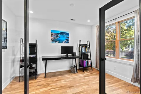 a view of an empty room with workspace and a flat screen tv