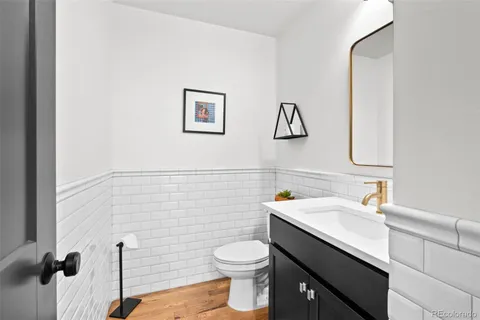 a bathroom with a toilet sink vanity and mirror
