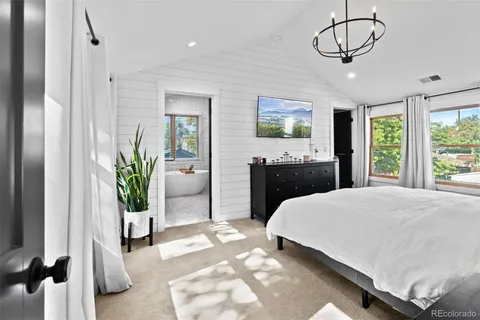 a bedroom with a balcony a bed and a chandelier