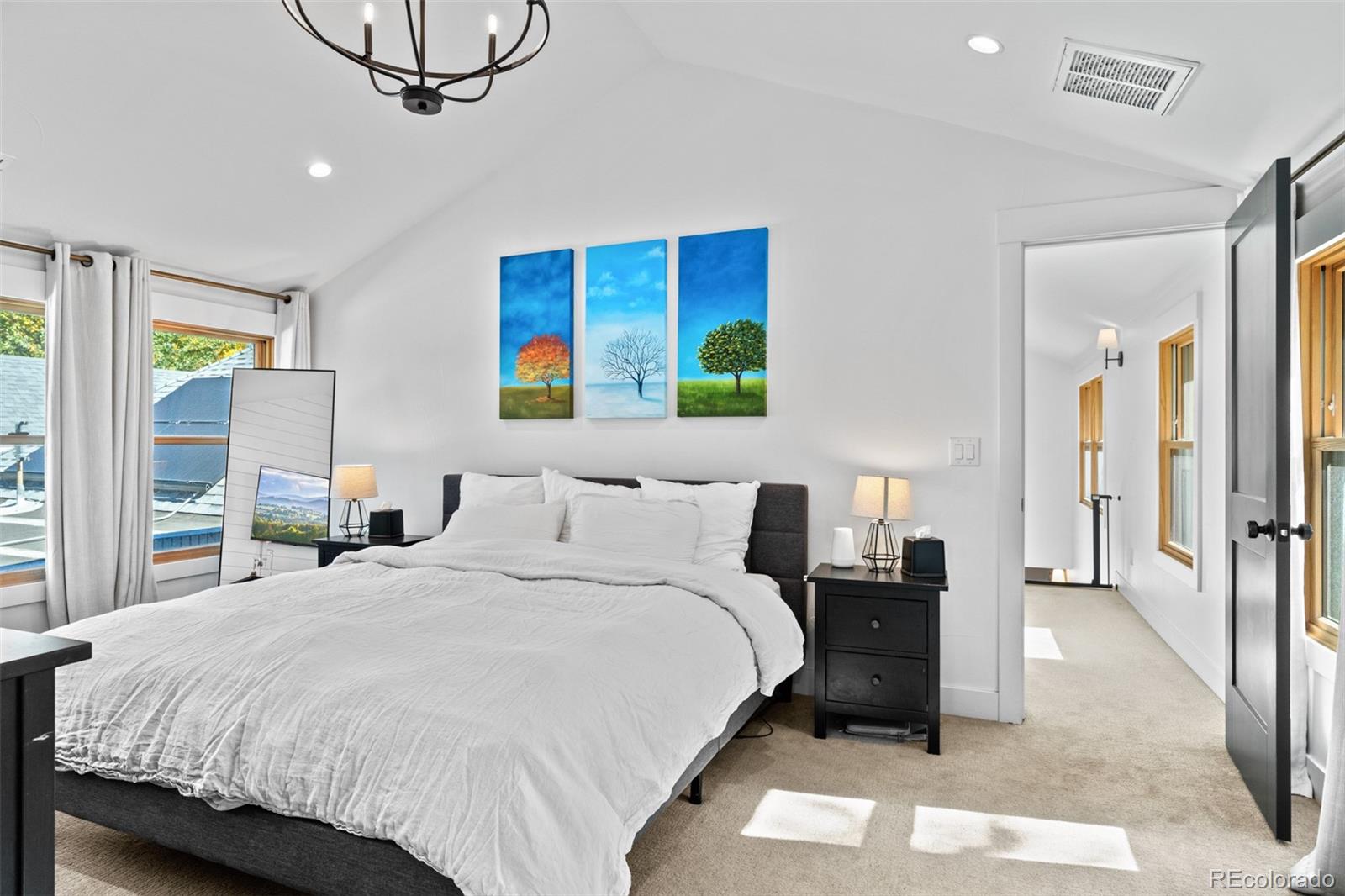 333 Delaware Street Denver, CO 80223 - Photo 24 of 44 a bedroom with a bed a mirror on dresser and a chandelier