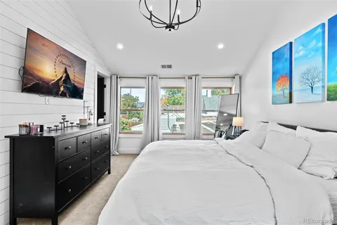 a large bedroom with a large bed and flat tv screen