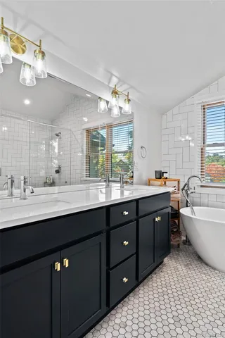a bathroom with a granite countertop sink a large mirror and a bathtub