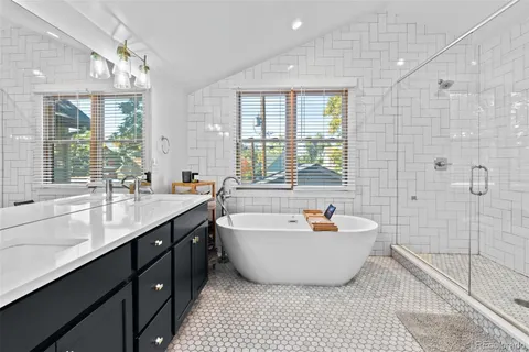 a spacious bathroom with a tub sink and mirror