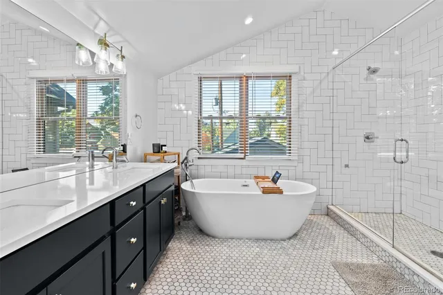a spacious bathroom with a tub sink and mirror