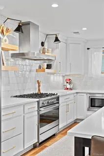 a kitchen with white cabinets and appliances