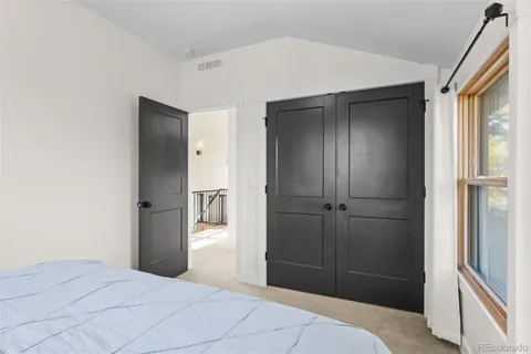 a bedroom with a bed and a refrigerator