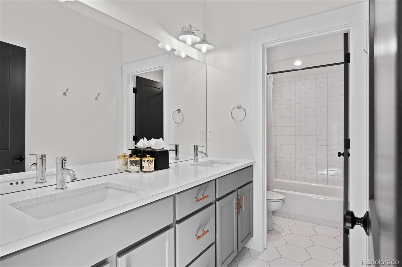 333 Delaware Street Denver, CO 80223 - Photo 35 of 44 a bathroom with a double vanity sink a mirror and a bathtub