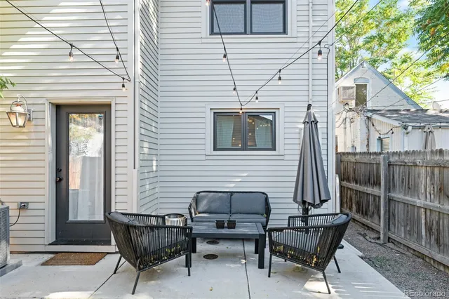 a patio with table and chairs and potted plants