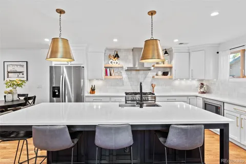 a kitchen with stainless steel appliances a dining table chairs and stove