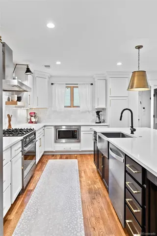 a kitchen with stainless steel appliances granite countertop a stove sink and cabinets