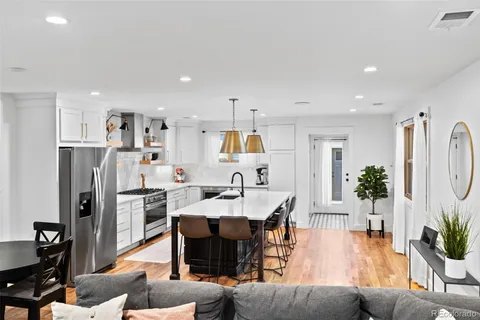 a living room with stainless steel appliances kitchen island granite countertop furniture and a dining table