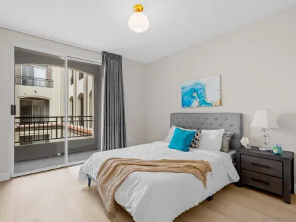 a bedroom with a bed and a painting on the wall