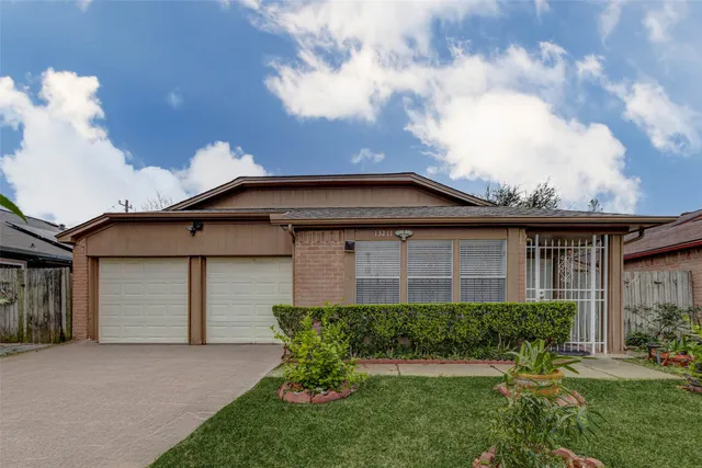 a front view of a house with a garden and yard