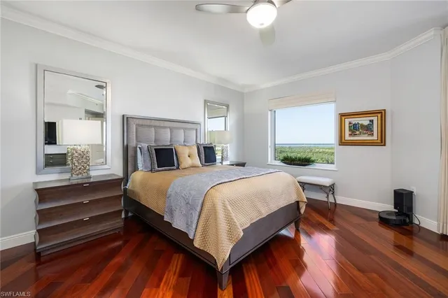 a bedroom with a bed a table and painting on the wall