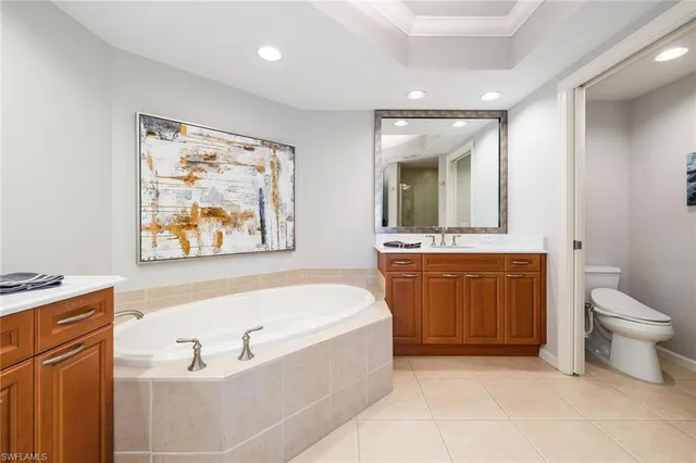 a bathroom with a tub a sink and mirror