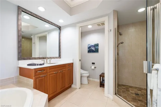 a spacious bathroom with a double vanity sink toilet mirror and shower
