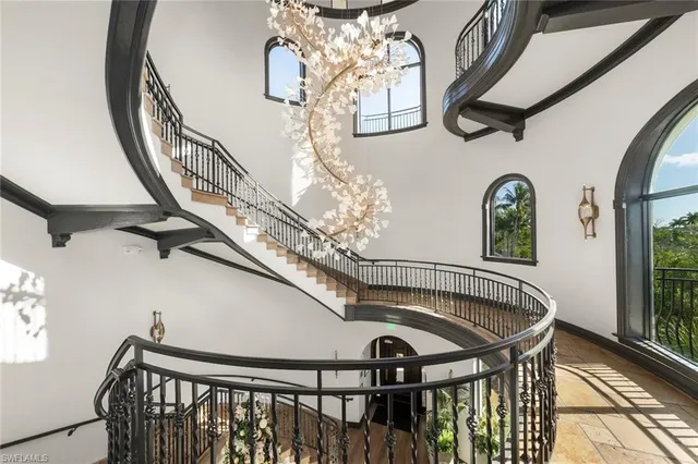 a view of staircase with railing and a chandelier