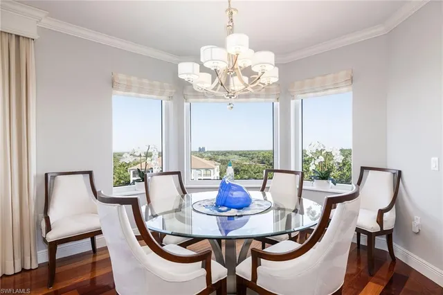 a view of a dining room with furniture a chandelier and wooden floor