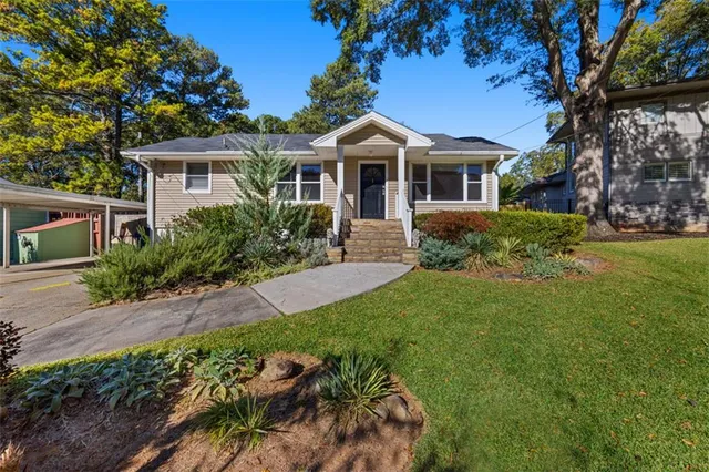 a front view of a house with a yard and potted plants