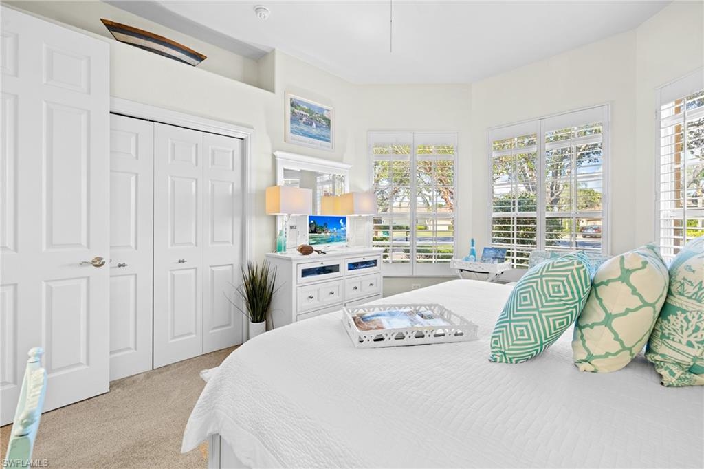 6737 Bent Grass Drive Naples, FL 34113 - Photo 22 of 31 a bedroom with a bed mirror and a large window