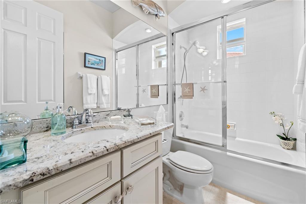 6737 Bent Grass Drive Naples, FL 34113 - Photo 24 of 31 a bathroom with a granite countertop sink toilet and shower