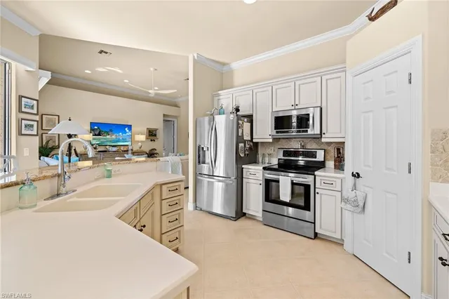 a kitchen with white cabinets and stainless steel appliances