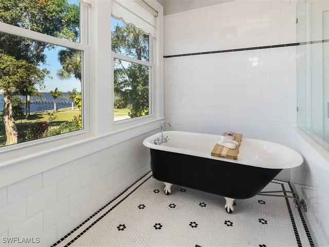 a bath tub sitting in a bathroom next to a window
