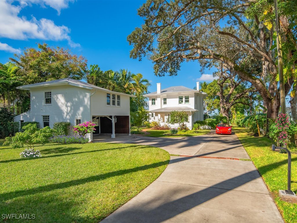 101 Fairview Avenue Fort Myers, FL 33905 - Photo 4 of 34 a view of a white house with a big yard and potted plants and a large tree