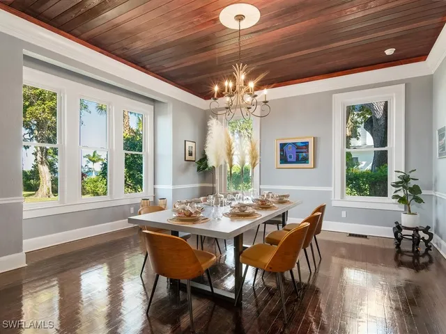 a dining room with furniture a chandelier and wooden floor