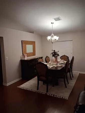 a view of a dining room with furniture and chandelier