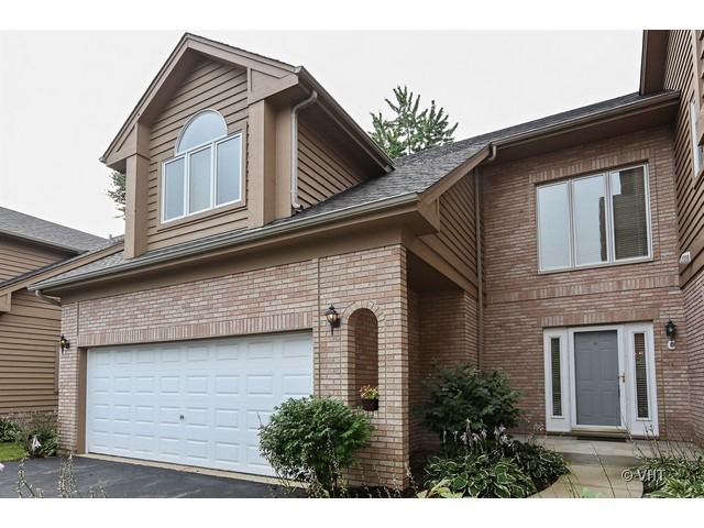 a front view of a house with plants