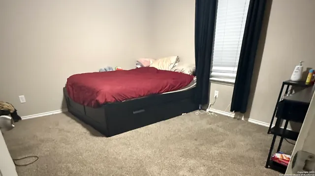 a bed sitting in a bedroom next to a window