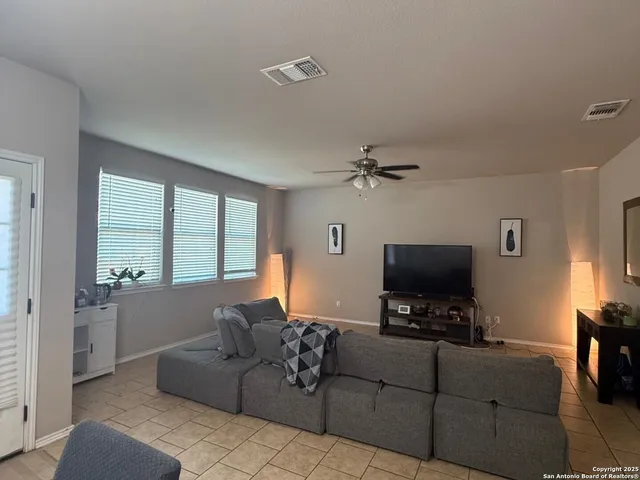 a living room with furniture a flat screen tv and a window