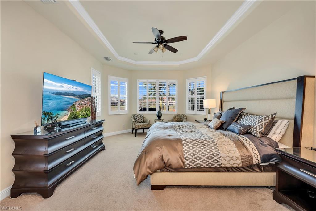 7810 Martino Circle Naples, FL 34112 - Photo 12 of 23 a spacious bedroom with a bed and a flat screen tv