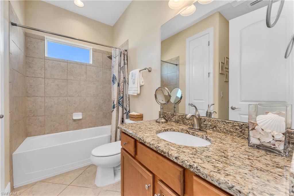 7810 Martino Circle Naples, FL 34112 - Photo 17 of 23 a bathroom with a granite countertop sink a toilet and shower