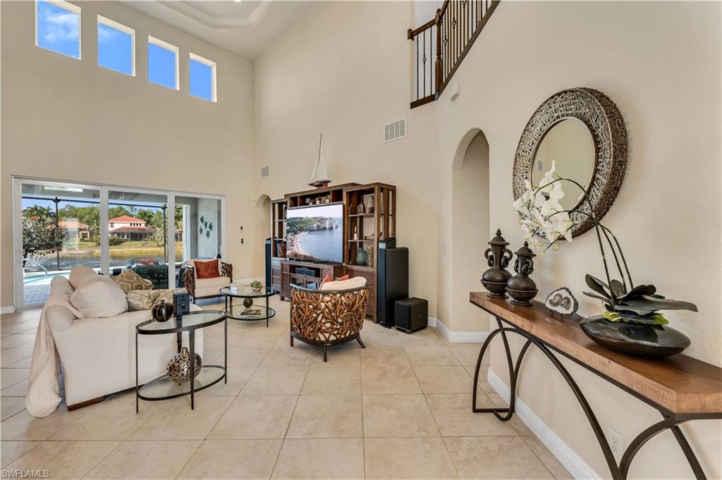 7810 Martino Circle Naples, FL 34112 - Photo 3 of 23 a living room with furniture a flat screen tv and a window