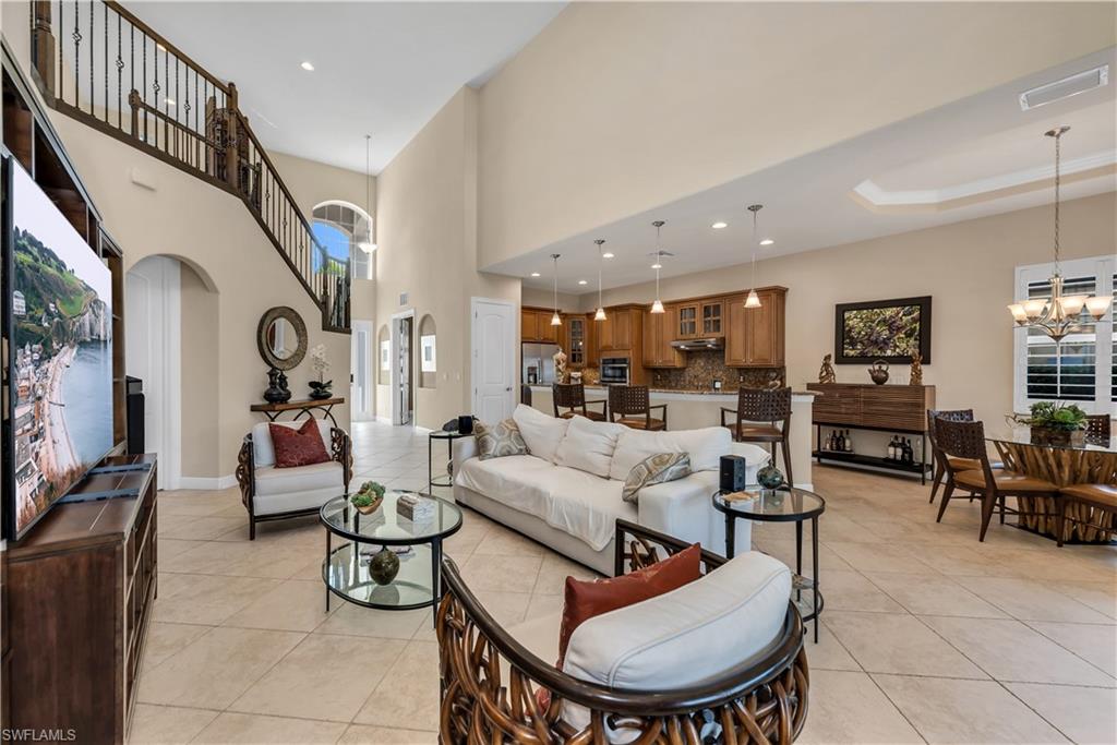 7810 Martino Circle Naples, FL 34112 - Photo 4 of 23 a living room with furniture kitchen view and a flat screen tv