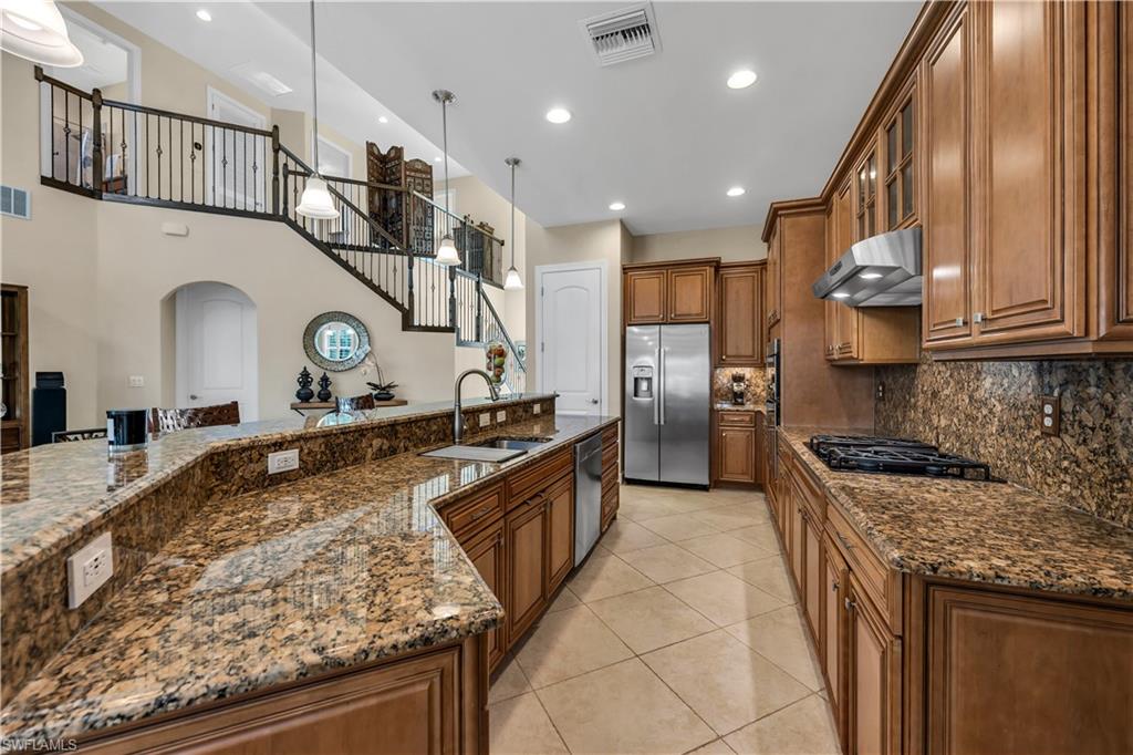 7810 Martino Circle Naples, FL 34112 - Photo 5 of 23 a large kitchen with stainless steel appliances granite countertop a stove and a sink
