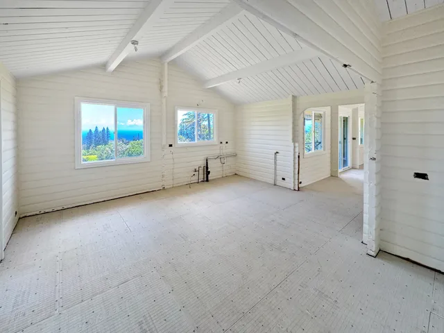 en empty room with windows and ceiling fan