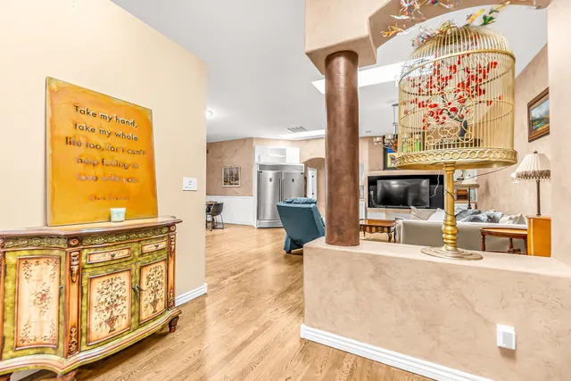 a view of a kitchen with stainless steel appliances wooden floor and a large window