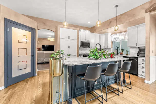 a kitchen with a table chairs refrigerator and wooden cabinets