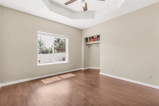 an empty room with a window and wooden floor