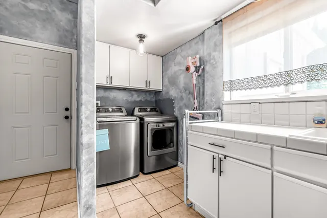 a kitchen with white cabinets and white appliances