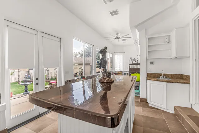 a kitchen with kitchen island a counter top space a sink stainless steel appliances and cabinets
