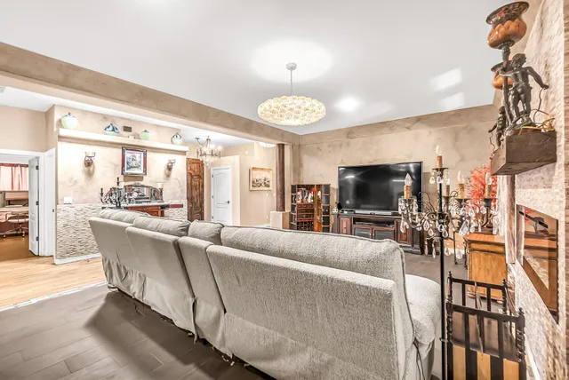 a living room with furniture a flat screen tv and a chandelier